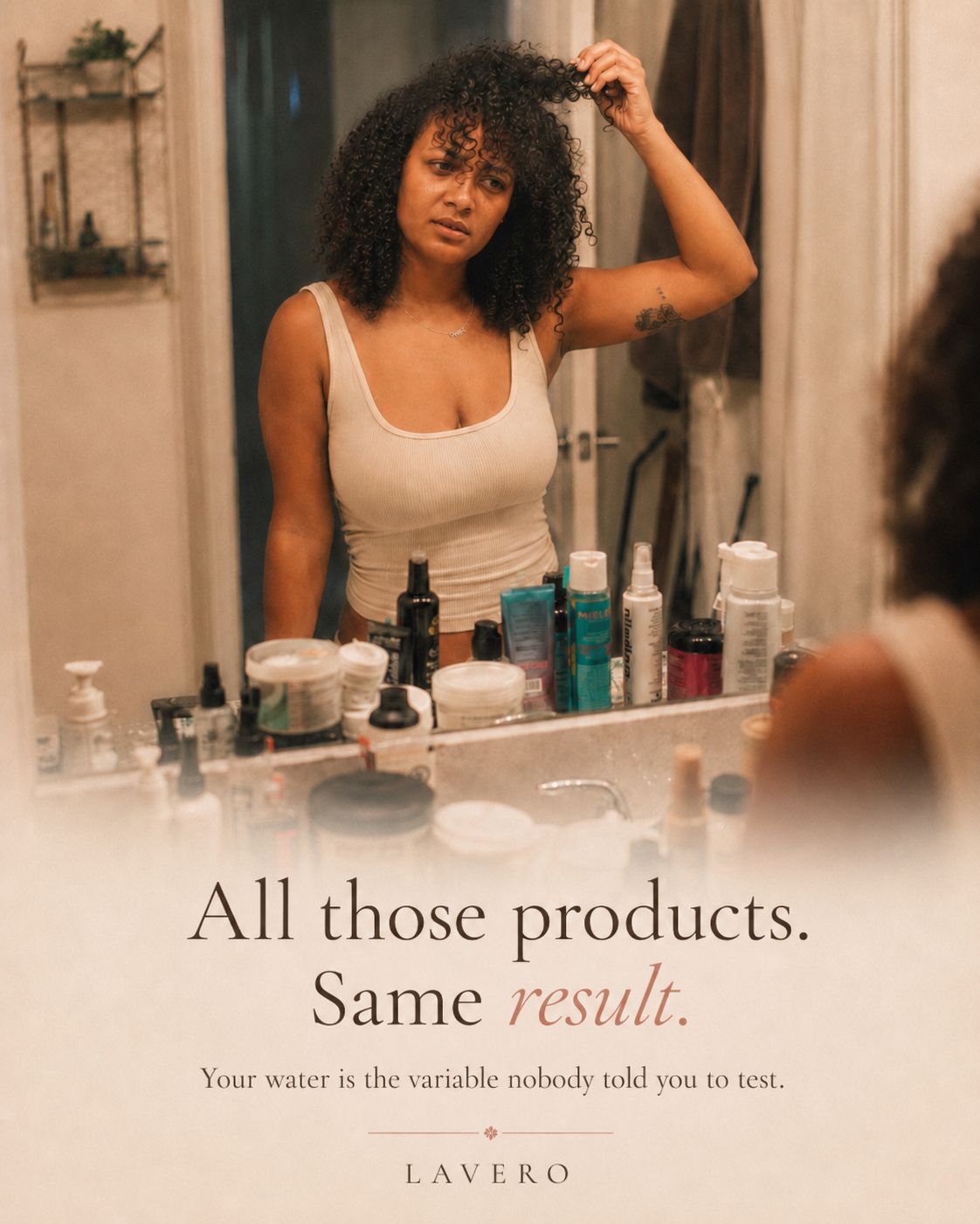 Woman looking at her curls in a bathroom mirror with hair products on the counter